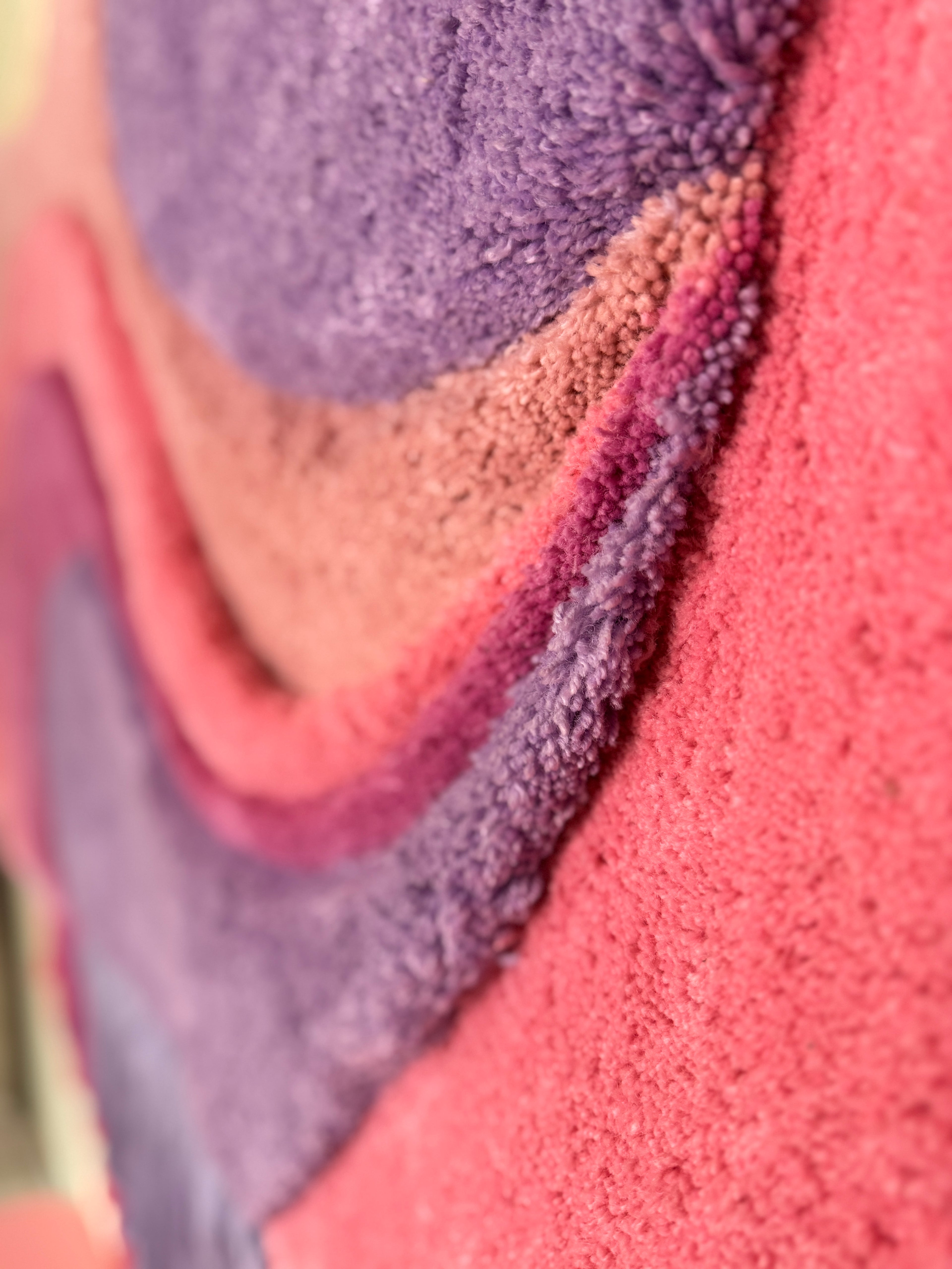 Close-up of textured fabric with purple, pink, and brown colors.